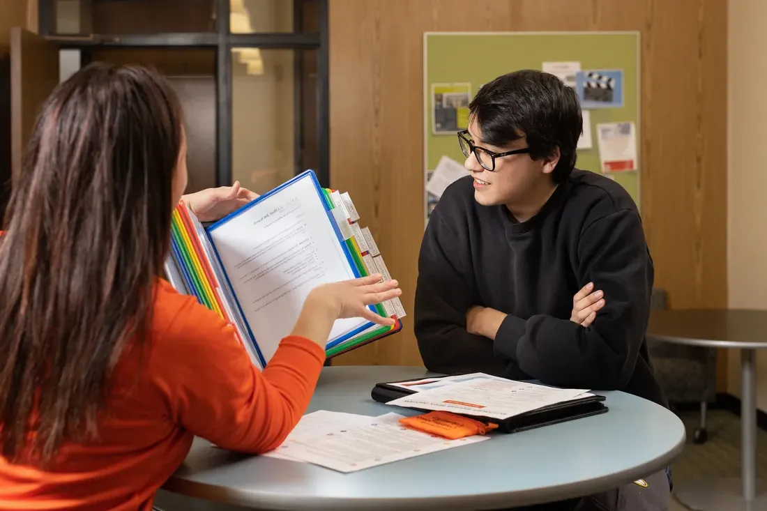 Two people looking at a book.